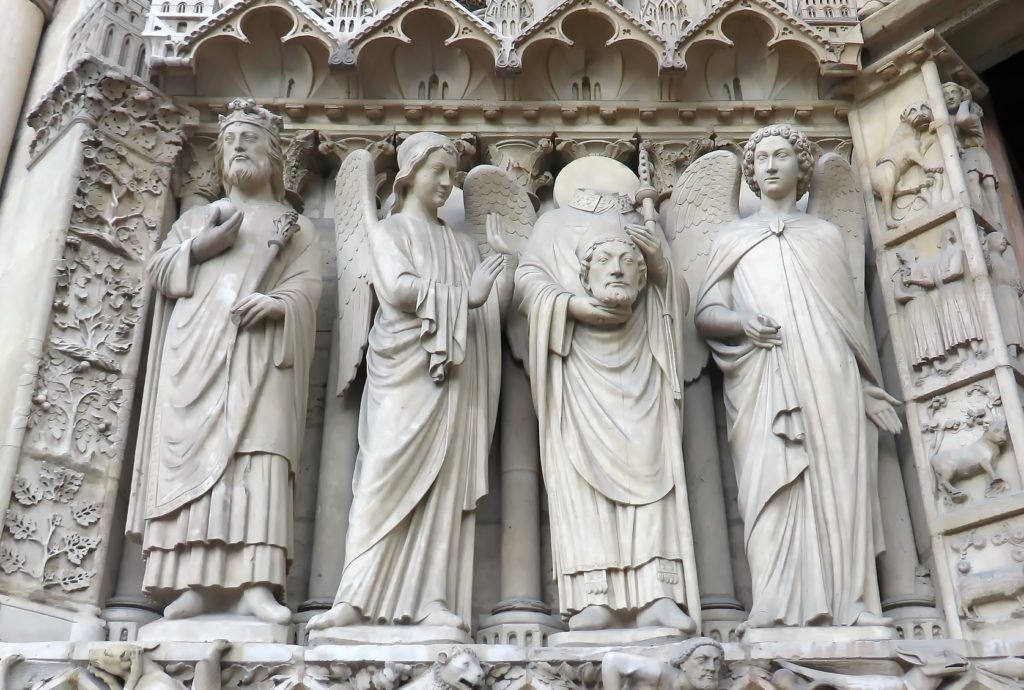 Statue de Saint-Denis portant sa tête dans ses mains, portail gauche de la cathédrale Notre-Dame à Paris. Photo : DEZALB - Pixabay